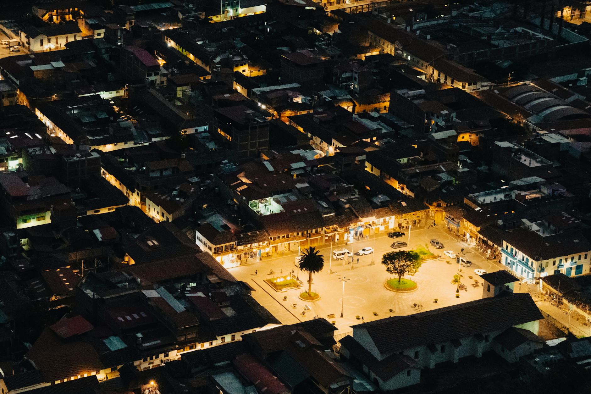 Nocne, lotnicze ujęcie oświetlonego rynku w górskim mieście