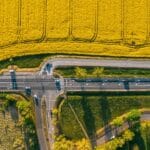 Poznań na budżecie: jedzenie, nocleg i atrakcje, które nie rujnują portfela Poznań z lotu ptaka, wiejska droga przecinająca pola uprawne