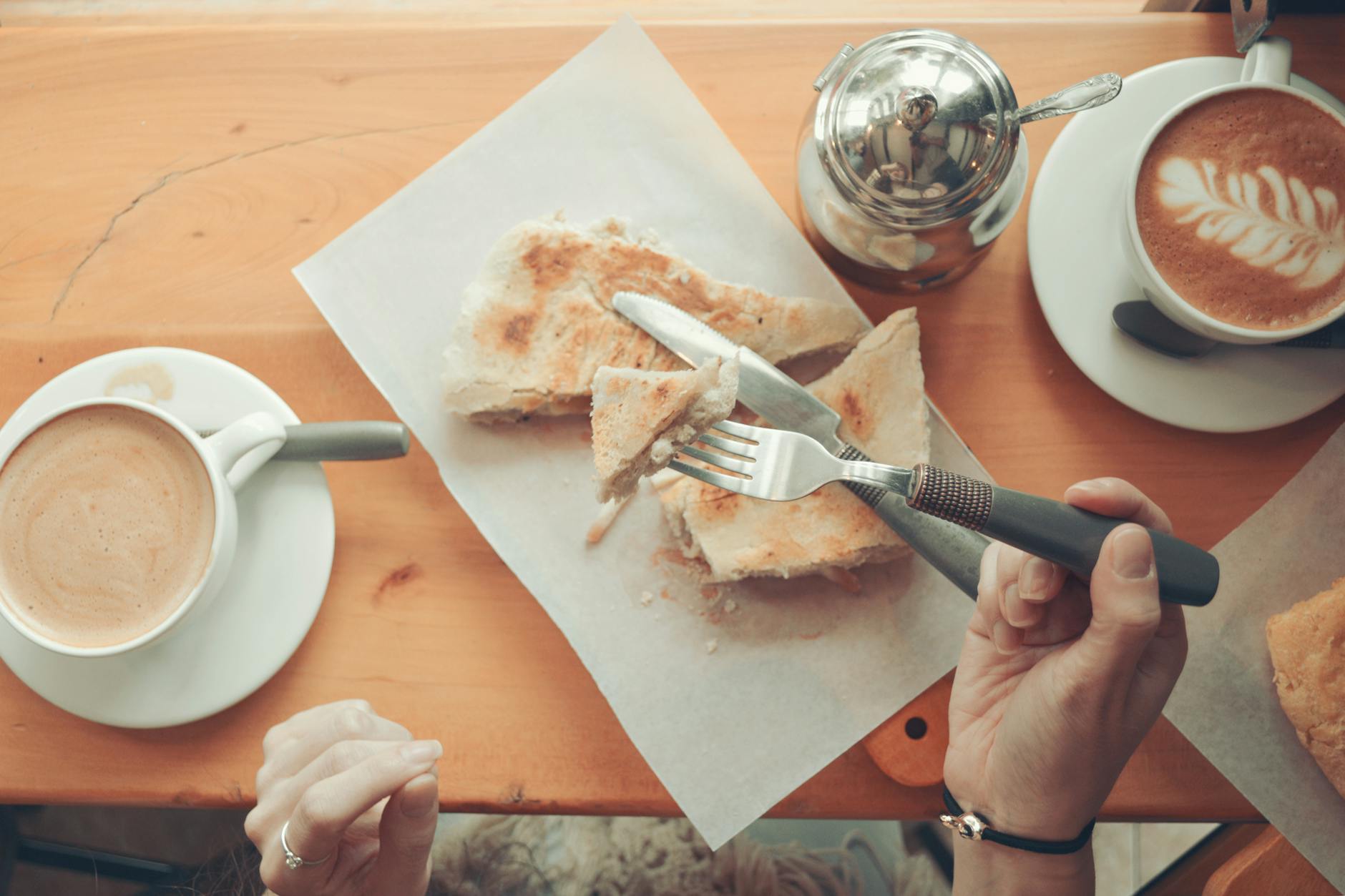 Kawa i tostowa kanapka na drewnianym stole w kawiarni w Swarzędzu