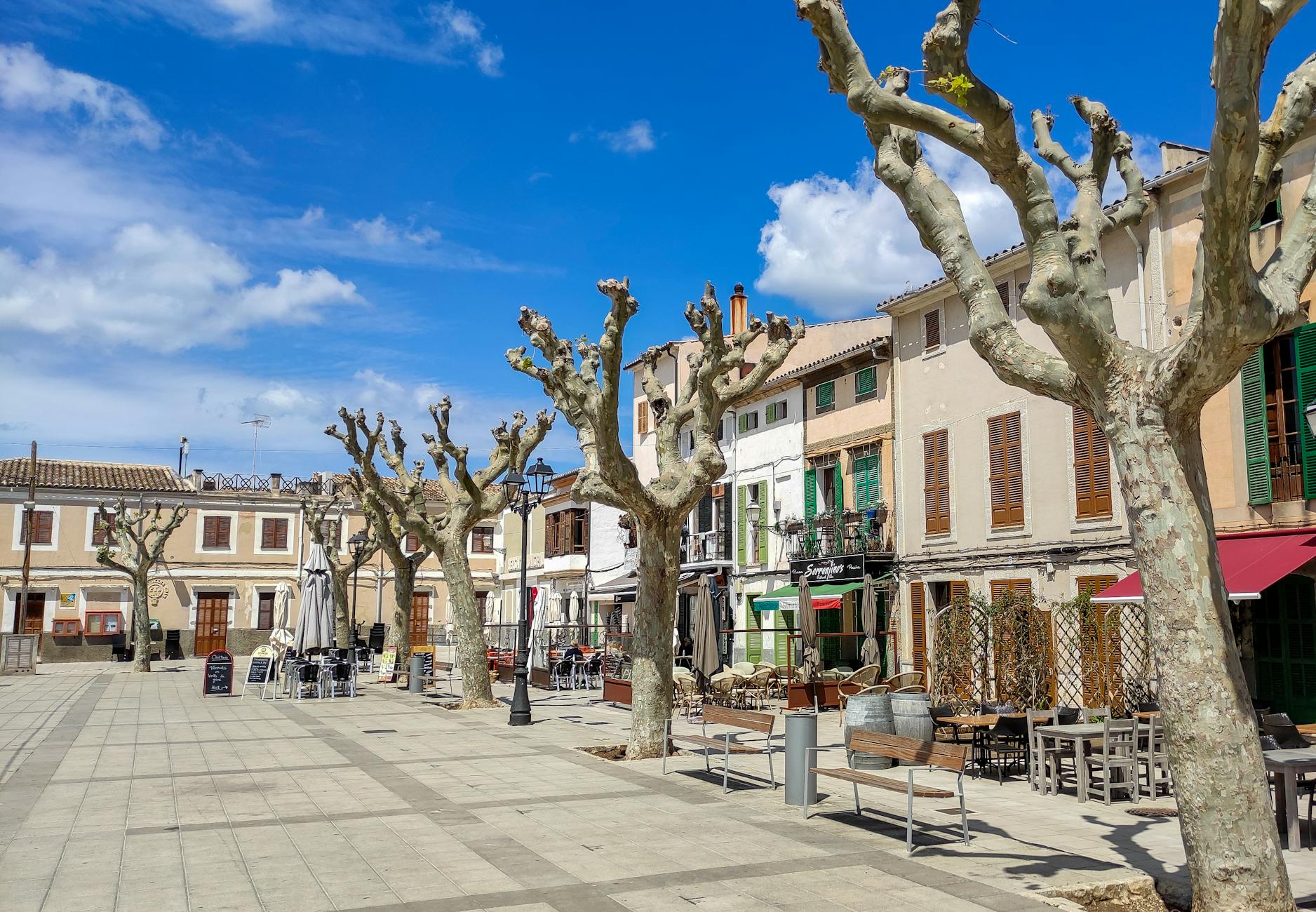 Letni deptak w śródmieściu z ludźmi spacerującymi między kamienicami