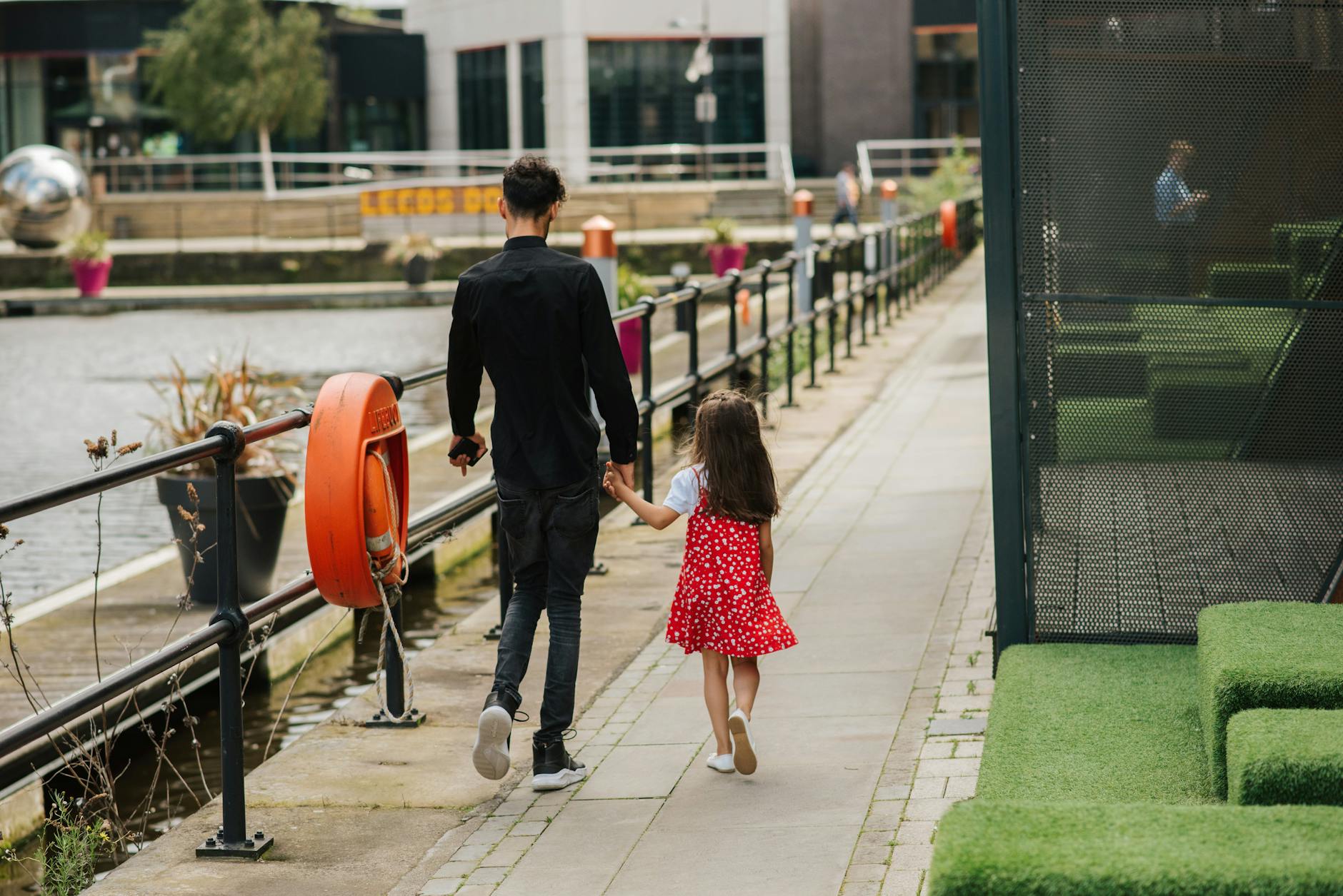 Tata spaceruje z córką nad rzeką w słoneczny dzień