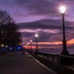 Wieczorny deptak nad rzeką oświetlony latarniami
