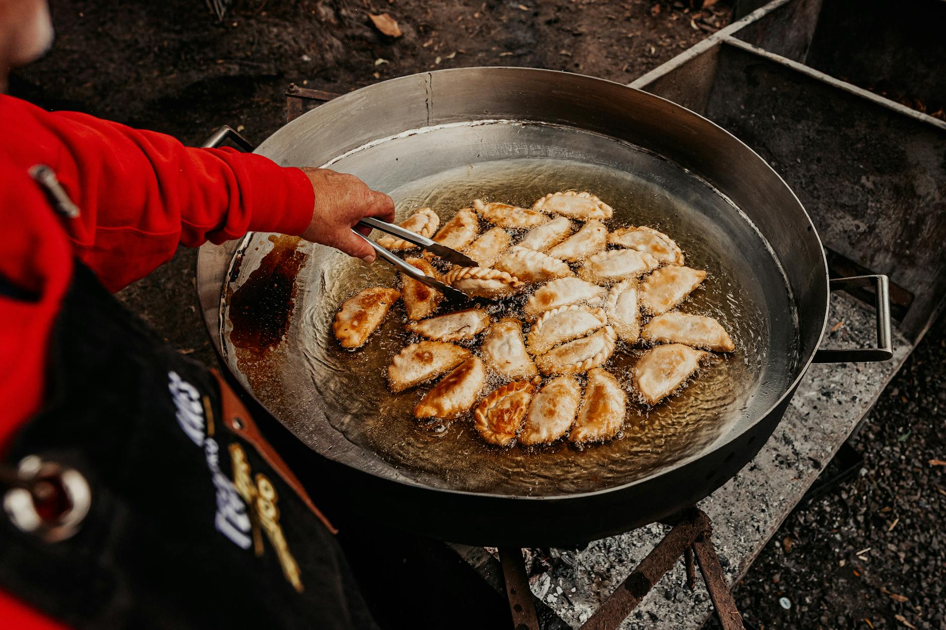 Uliczny sprzedawca smażący pierogi na targu z jedzeniem