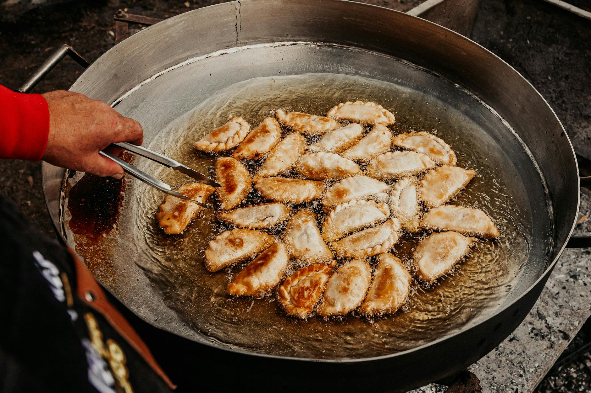 Złote empanady smażące się na głębokim oleju na ulicznym straganie