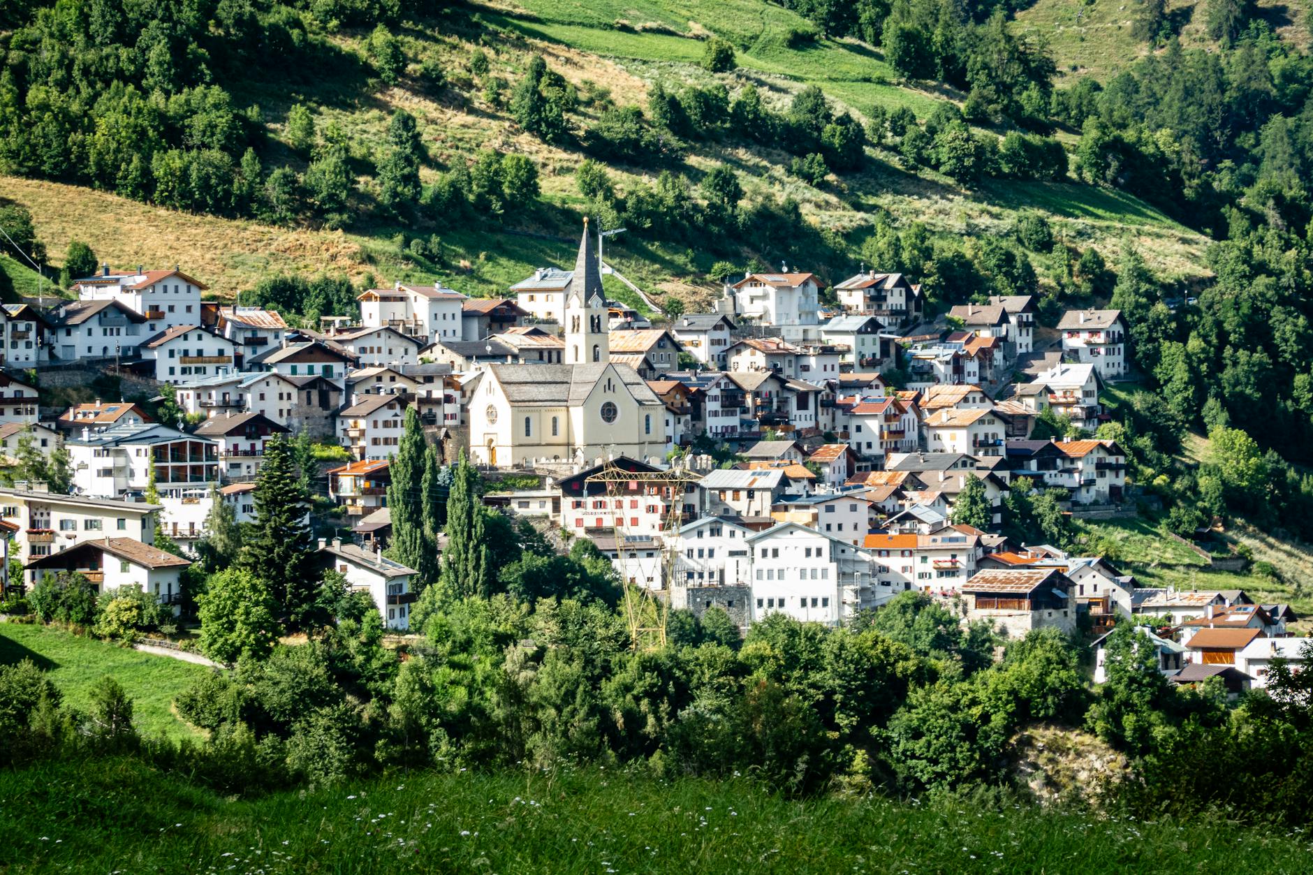 Górska alpejska wioska otoczona zielonymi wzgórzami