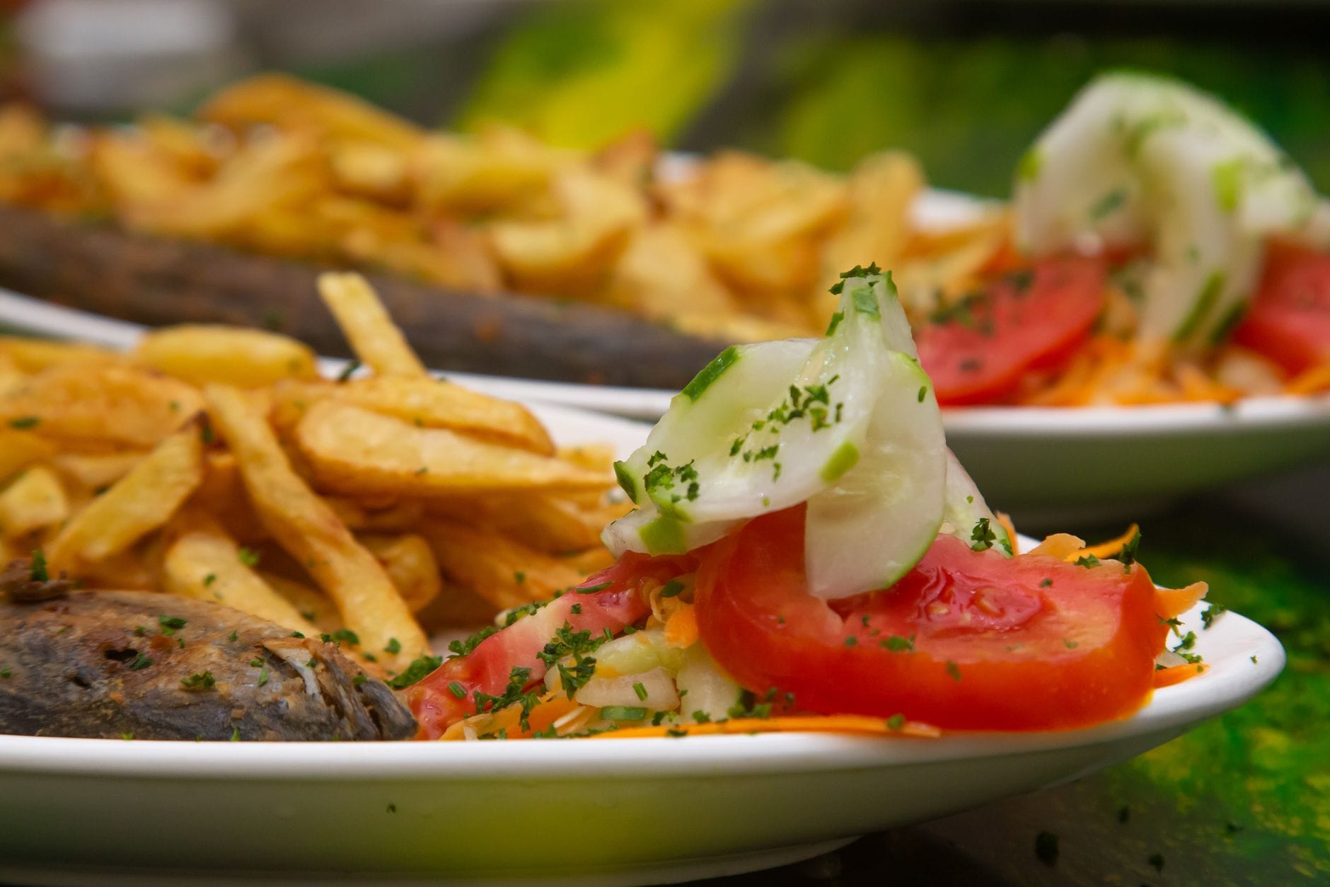 Zbliżenie na fish and chips z sałatką z ogórka i pomidora na talerzu